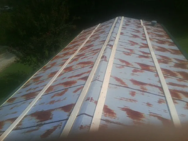 Rusted metal roof panels with new wood purlins before replacement — Storm Damage Roof Repair in Saint Clair by Roofing Brothers